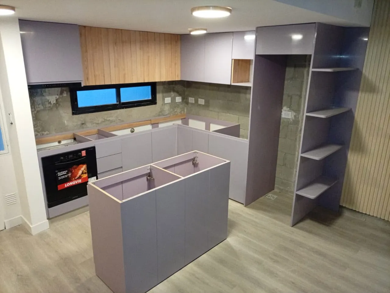 Cocina en etapa de instalación con muebles grises e isla central