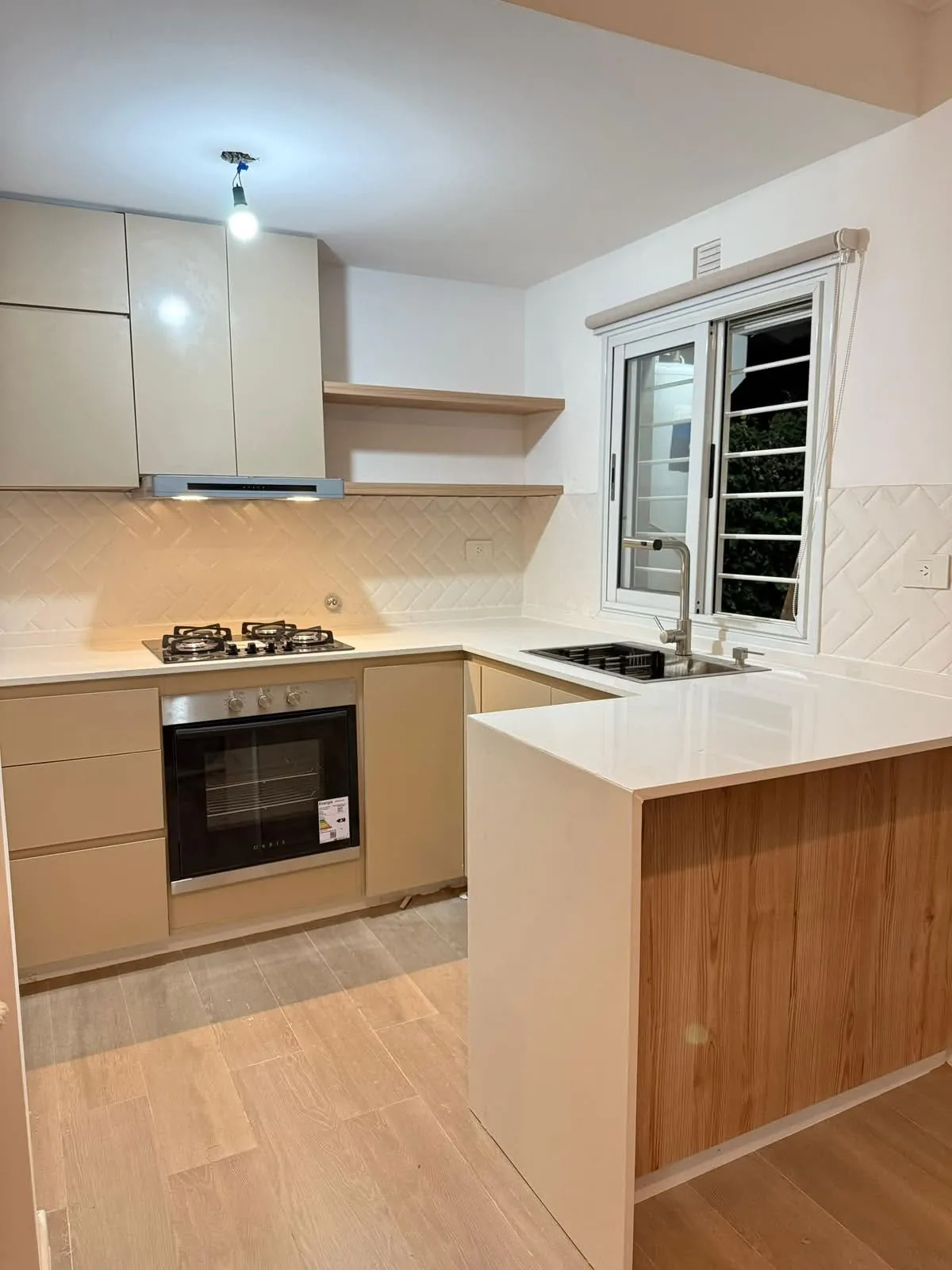 Cocina clara con península de madera y revestimiento en espiga
